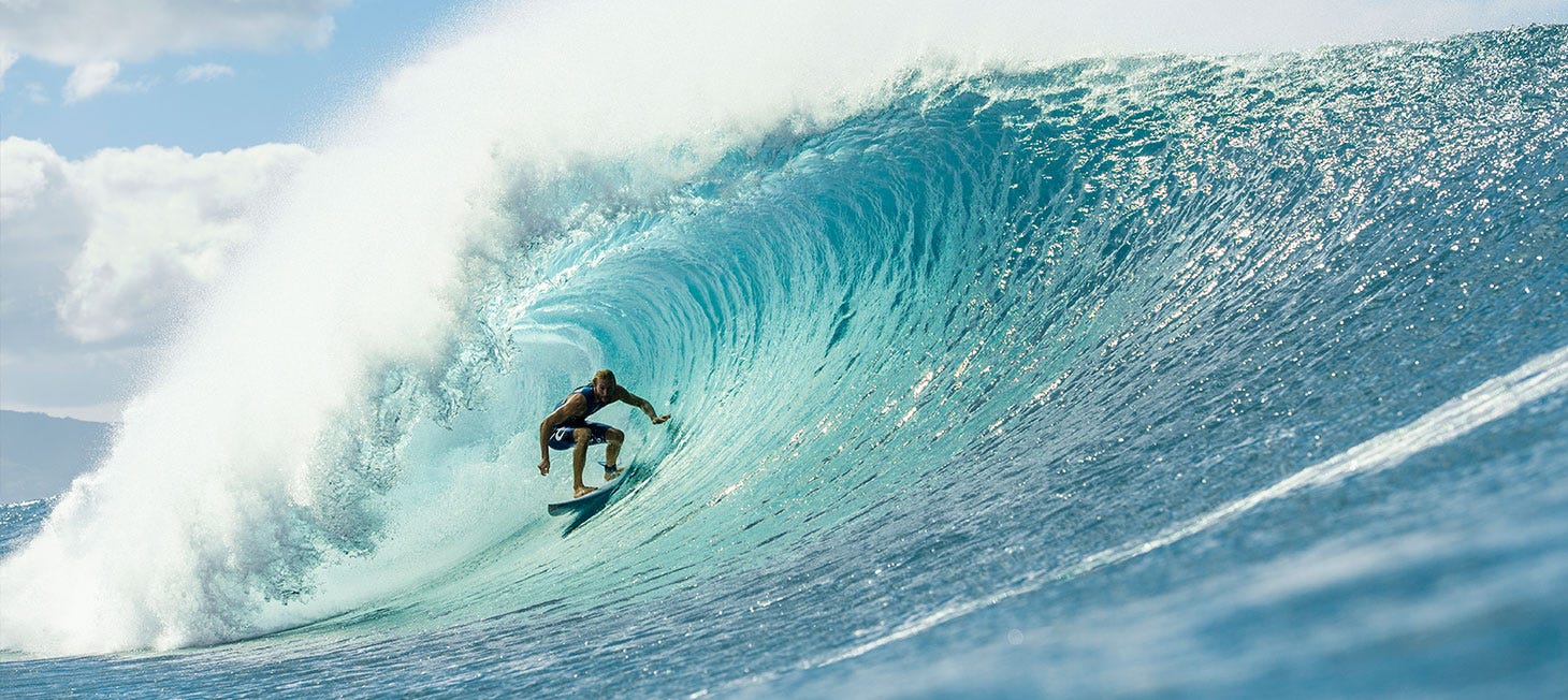 Owen Wright getting barrelled by a wave. Image links to video of Owen collecting plastic bottles to showcase Rip Curl's new recycled plastic boardshorts